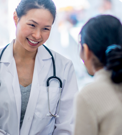 A doctor smiling while talking to a patient